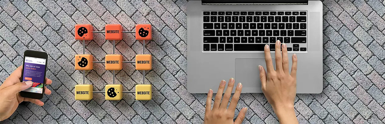 Handen op toetsenbord van een laptop met houten cookies ernaast